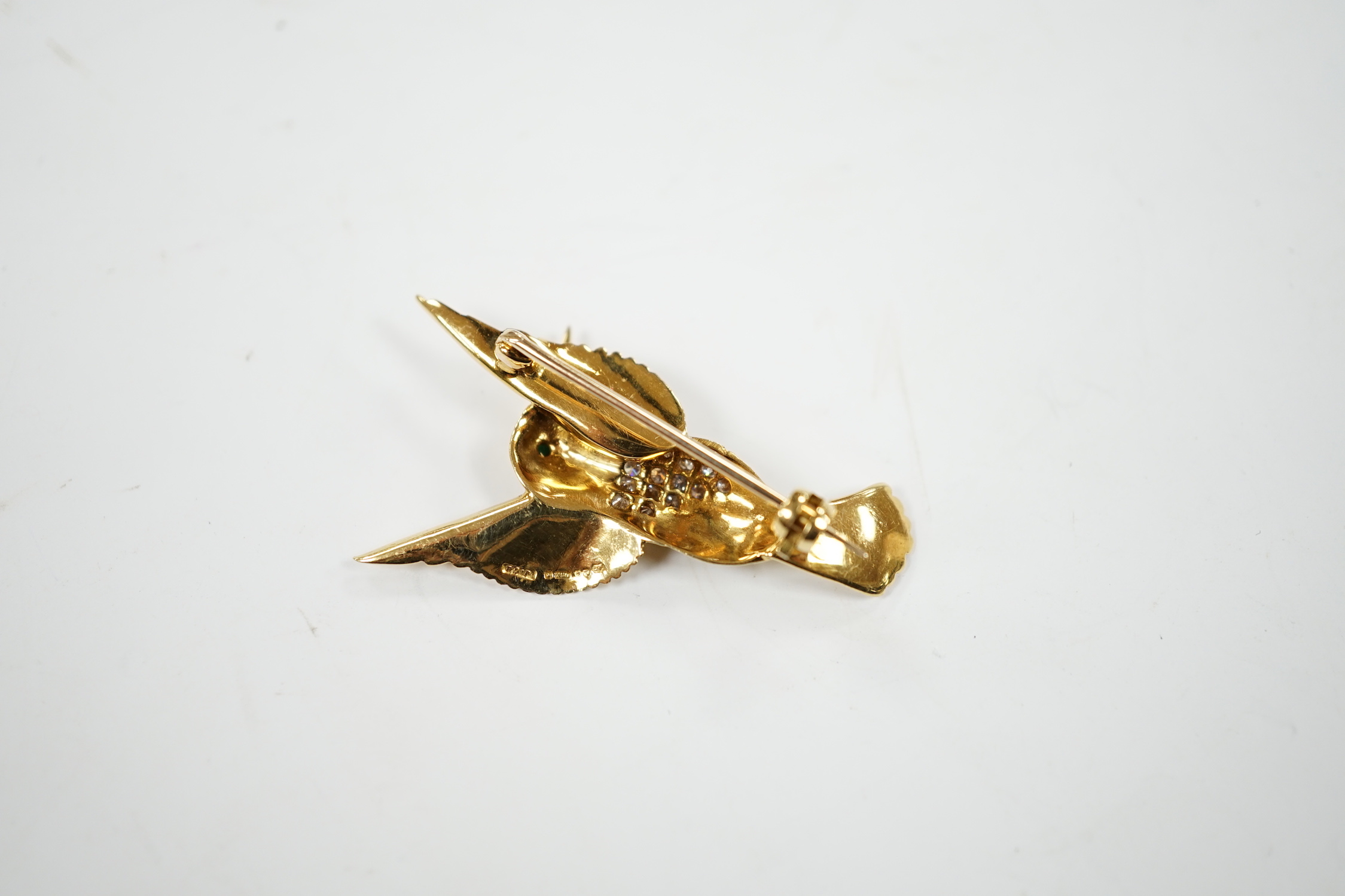 A modern 18ct and diamond cluster set kingfisher brooch, with emerald? set eye, 35mm, gross weight 5.3 grams.